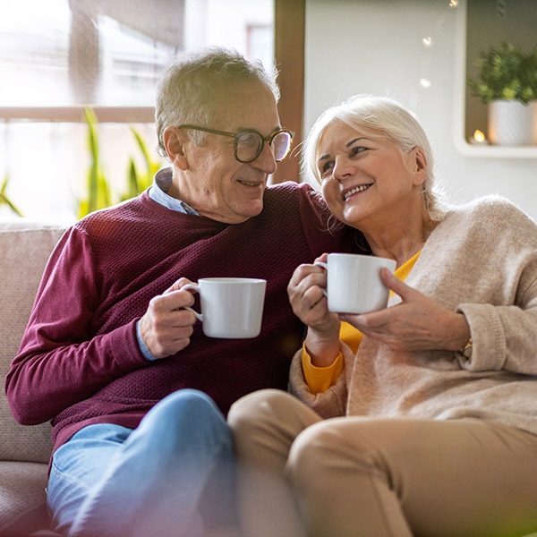 mature couple drinking coffee on the couch together