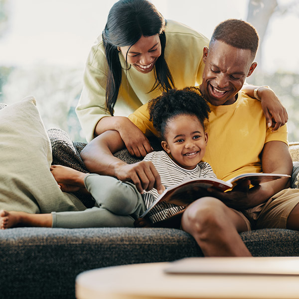 family of three reading a book together