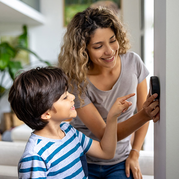 mom and son checking the thermostat